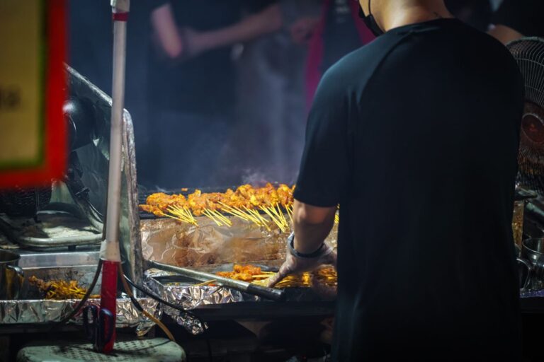 Grilling satay skewers at night market in Lau Pa Sat, Singapore