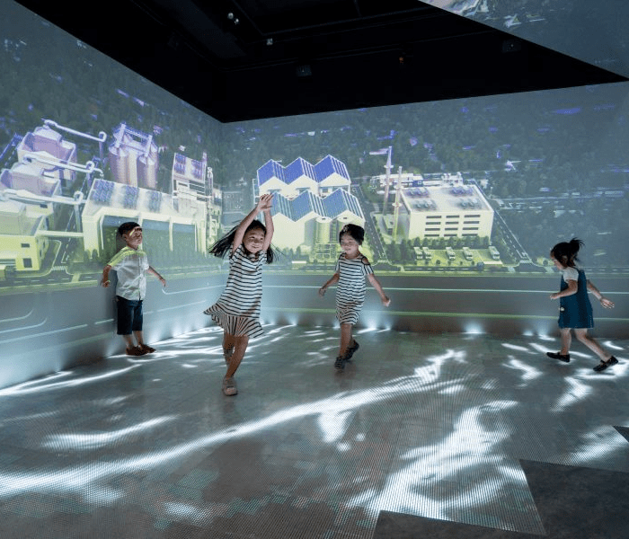 Children experiencing a virtual reality exhibit at Singapore City Gallery, displaying the future vision of Singapore as a smart city.