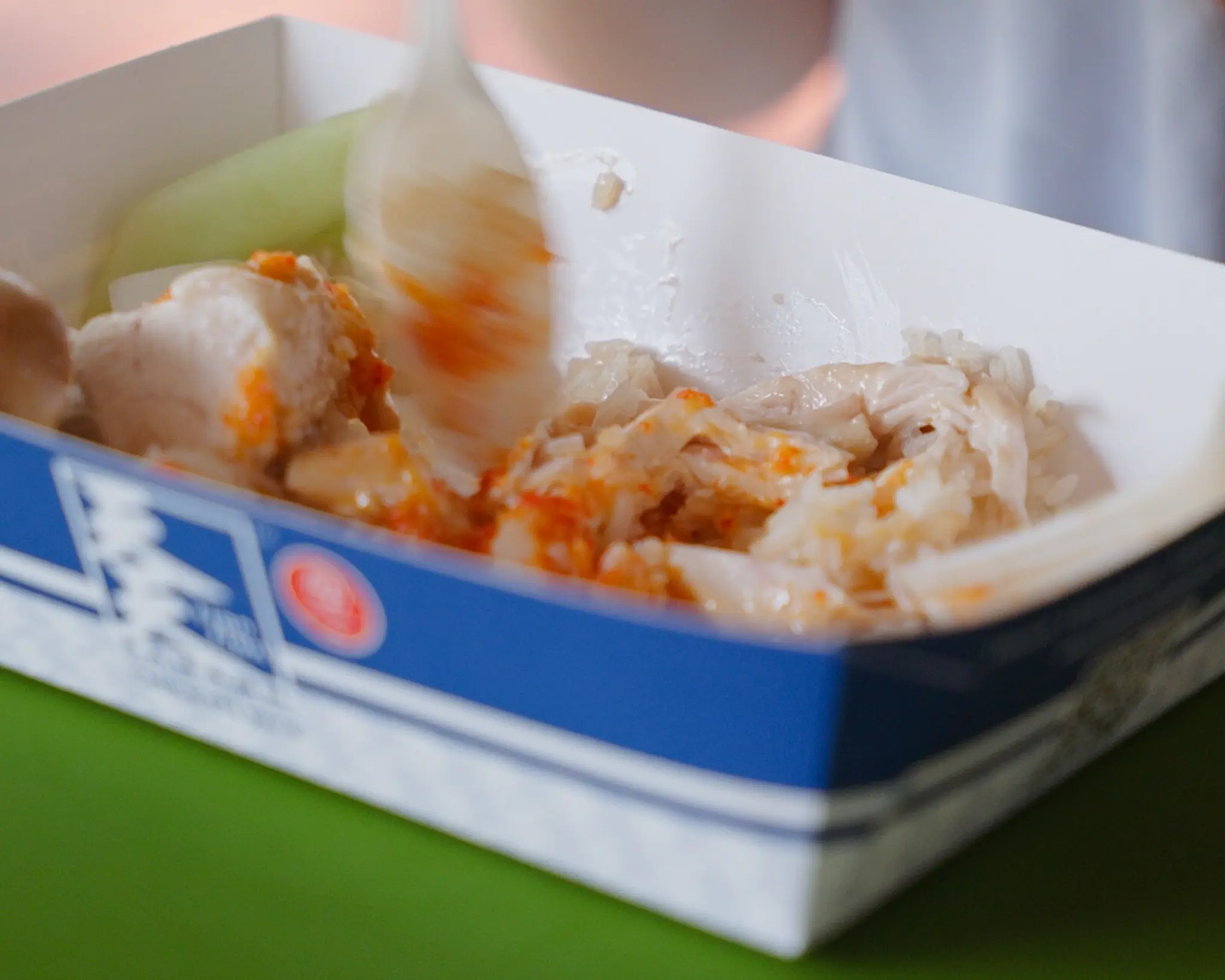 Takeaway box of Tian Tian Hainanese chicken rice with poached chicken, cucumber, and signature chili sauce at Maxwell Food Centre, Singapore