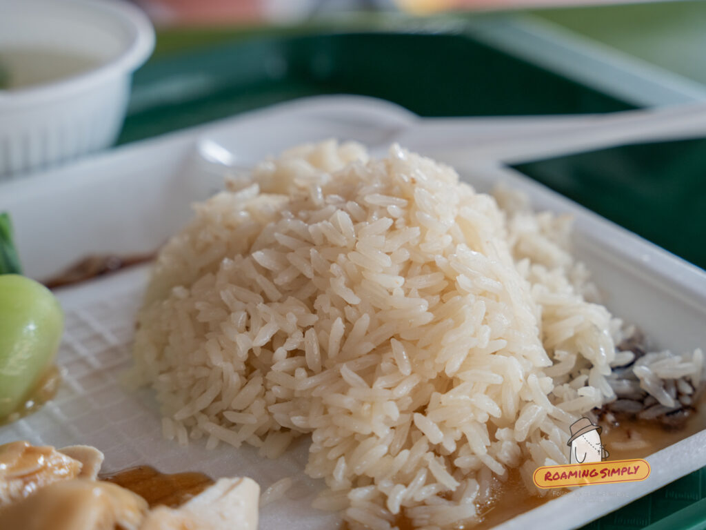 Close-up of a mound of fragrant Hainanese chicken rice at Ah Tai, showing the glossy, individual grains cooked in chicken stock and aromatics.