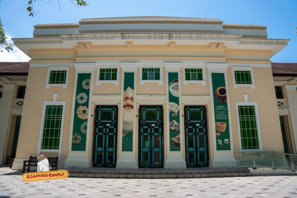 Neo-classical façade of a heritage gallery at Fort Canning Park, with green banners showing ancient coins and artefacts