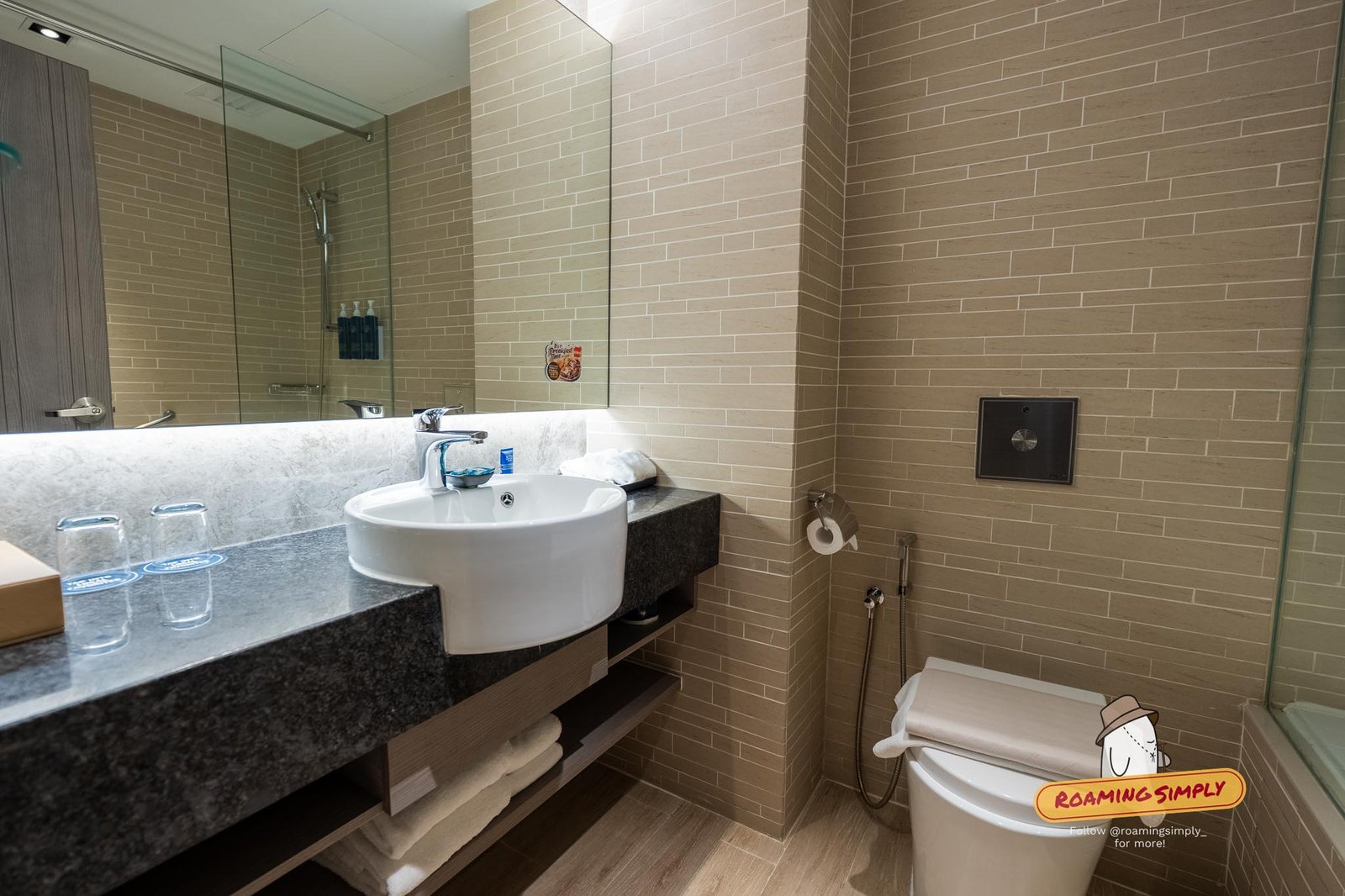 Bathroom vanity and generous sink under a well-lit mirror
