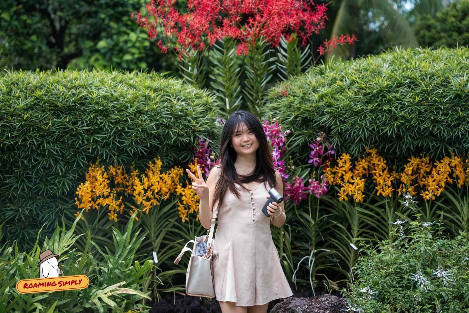 A visitor among vibrant red, yellow and magenta orchid displays at the National Orchid Garden, Singapore